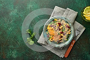 Mexican black bean corn quinoa salad with caramelized lemon in old vintage clay bowl on a dark green concrete background.