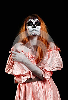 Mexican body art. God of death. Redhead girl in peachy dress. Woman monster. Creative dark make-up.