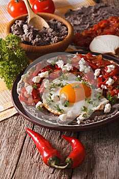 Mexican breakfast: huevos rancheros close-up. vertical