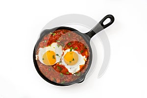 Mexican breakfast: Huevos rancheros in iron frying pan isolated