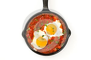 Mexican breakfast: Huevos rancheros in iron frying pan isolated