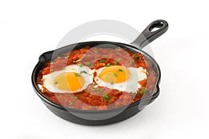 Mexican breakfast: Huevos rancheros in iron frying pan isolated