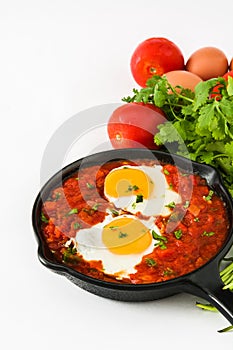 Mexican breakfast: Huevos rancheros in iron frying pan isolated