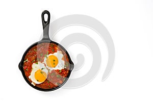 Mexican breakfast: Huevos rancheros in iron frying pan isolated
