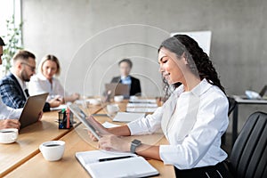 Mexican Businesswoman Using Digital Tablet On Corporate Meeting In Office