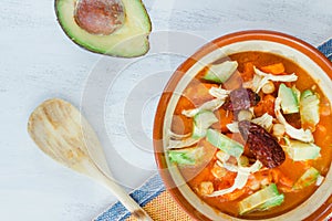 Mexican caldo tlalpeÃÂ±o Traditional soup with chipotle chile, avocado, chickpea, chicken, cheese and carrots