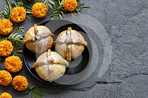 Mexican celebration, bread of death. Mexican parties with Dead bread and marigold flowers on gray stone background photo