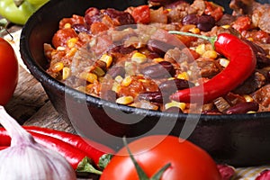 Mexican chili con carne in a pan on a wooden background