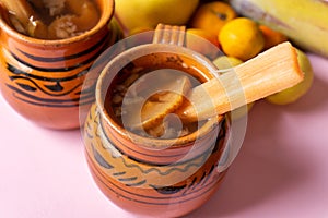 Mexican christmas punch with fruits on pink background