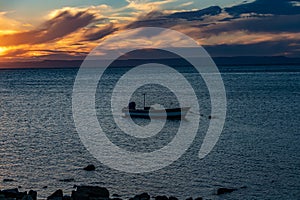 Mexican coastal sunset, motor boat anchored on calm waters