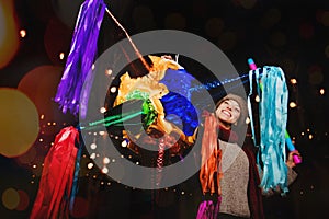 Mexican Colorful PiÃ±ata, Woman Holding a colorful PiÃ±ata celebrating Christmas in a traditional Posada in Mexico City