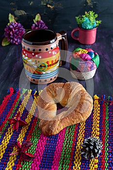 Mexican Cuernito Bread, Sugar Croissant and Coffee Jar on Woven Tablecloth.