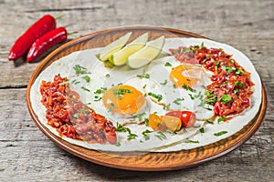 Mexican cuisine. Breakfast huevos rancheros on a wooden table