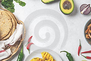 Mexican cuisine food frame - ingredients for mexican tacos al pastor, corn tortillas, chili pepper, pineapple, avocado, cilantro,