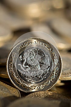 Mexican currency in the foreground, with many more coins in the background