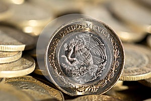 Mexican currency in the foreground, with many more coins in the background, macro, Horizontal