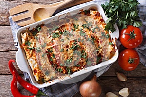 Mexican enchilada in a baking dish horizontal top view close-up