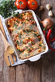 Mexican enchilada in a baking dish vertical top view photo