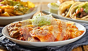 Mexican enchilada platter with red sauce, refried beans and rice