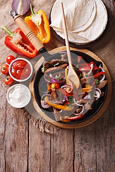 Mexican fajitas on a table, rustic style vertical top view