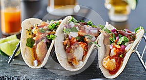 Mexican fish tacos in metal tray with hot sauce