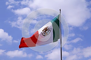 Mexican flag in a blue sky with clouds, mexico city I