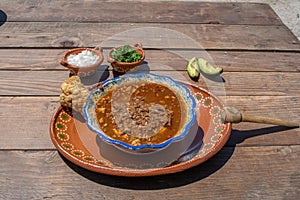 Mexican food with birria, hot sauce and chicharron with avocados photo