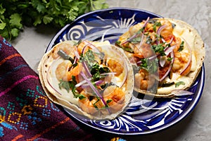 Mexican food. Shrimp tacos with melted cheese and poblano pepper called gobernador on grey background photo