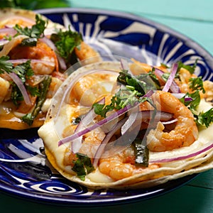 Mexican food. Shrimp tacos with melted cheese and poblano pepper called gobernador on turquoise background photo