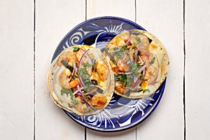 Mexican food. Shrimp tacos with melted cheese and poblano pepper called gobernador on white background photo