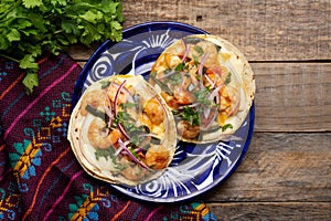 Mexican food. Shrimp tacos with melted cheese and poblano pepper called gobernador on wooden background photo