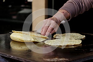Mexican fresh corn tortillas being cooked on a traditional `comal`