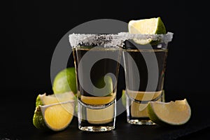 Mexican Gold Tequila with lime slices and salt.