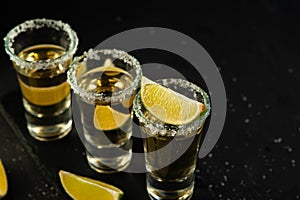 Mexican Gold Tequila with lime slices and salt, top view