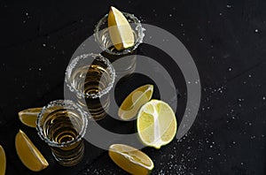 Mexican Gold Tequila with lime slices and salt, top view