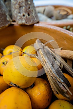 Mexican hawthorns and cinnamon sticks in a clay bowl