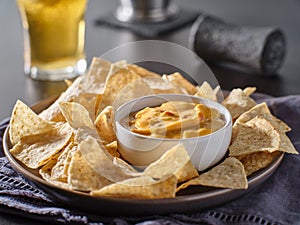 Mexican hot queso cheese dip with corn tortilla chips on plate photo