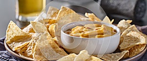 Mexican hot queso cheese dip with corn tortilla chips on plate