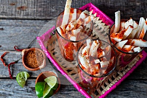 Mexican jicama fruit cutted with lime, chili powder and chamoy photo
