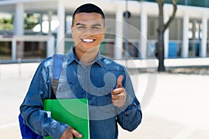 Mexican male student with backpack showing thumb up