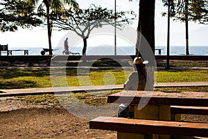 Mexican man enjoying the morning sun at the park on the boardwalk