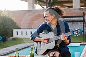 Mexican man playing guitar outside home in Mexico city