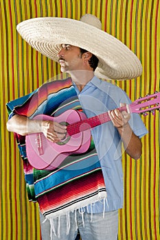 Mexican man serape poncho sombrero playing guitar photo