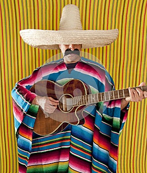 Mexican man serape poncho sombrero playing guitar photo