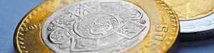 Mexican money lies on blue surface. Coin of 10 pesos closeup. Peso of Mexico. News about economy or currency. Loan and credit