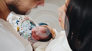 Mexican multiethnic new born boy at father's hands. Mother and father in post natal hospital department. Happy