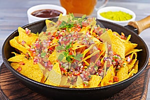 Mexican nachos with cheese. Corn chips with guacamole, salsa and tomato ketchup