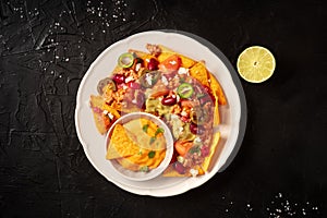 Mexican nachos with chili con carne, cheese dip and a lime