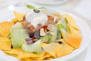 Mexican Nachos in white plate on dining table in mexican restaurant