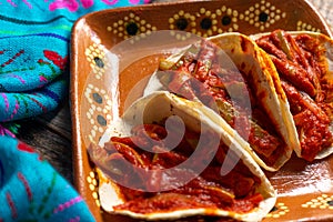 Mexican nopal cactus tacos with guajillo red sauce on wooden background photo